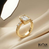 Diamond Ring with an Emerald-Cut Centerpiece and Timeless Gold Detailing - Bijoux Eclore