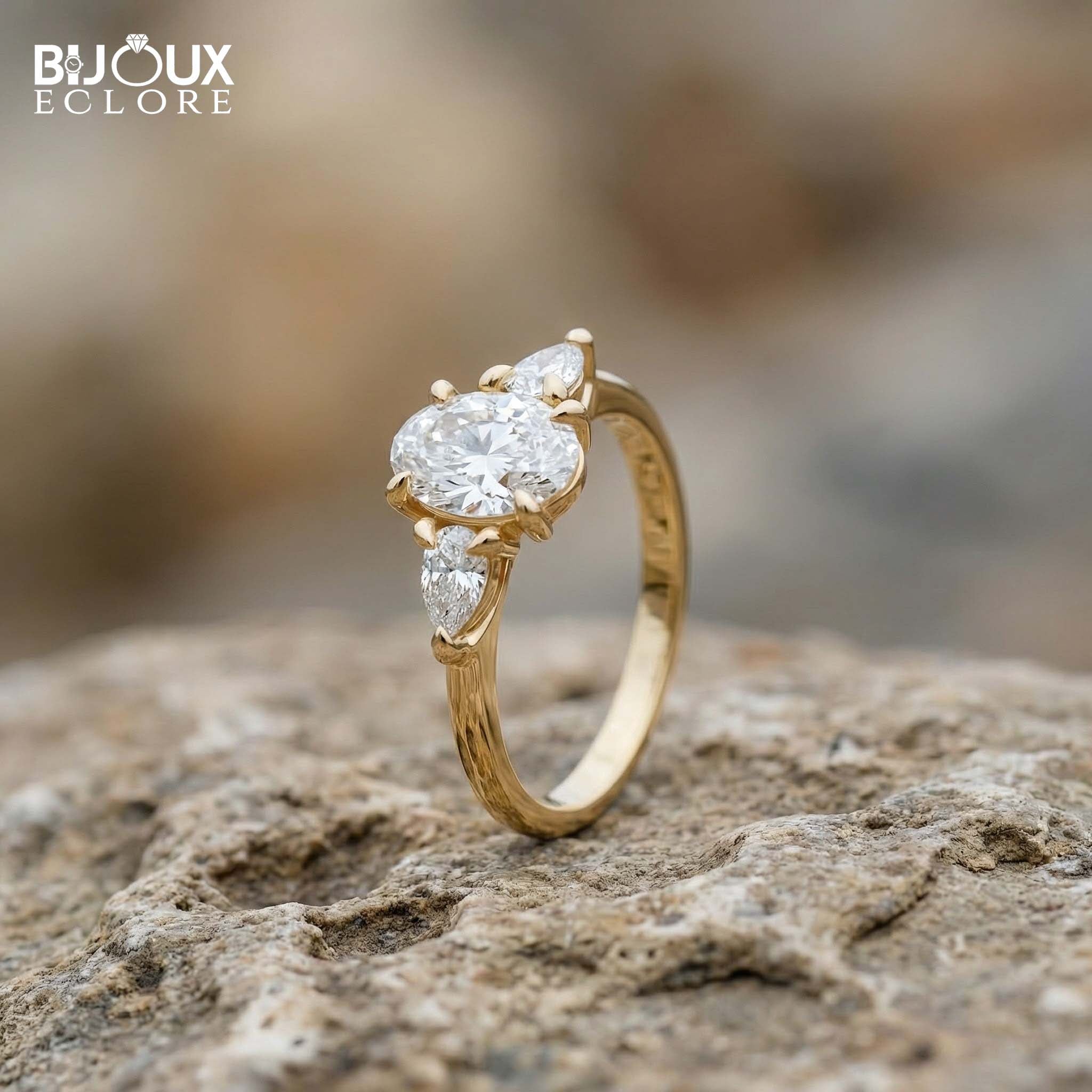 Oval-Cut Center Diamond with Sparkling Trilliant Side Stones Set in a Luxurious Yellow Gold Band - Bijoux Eclore