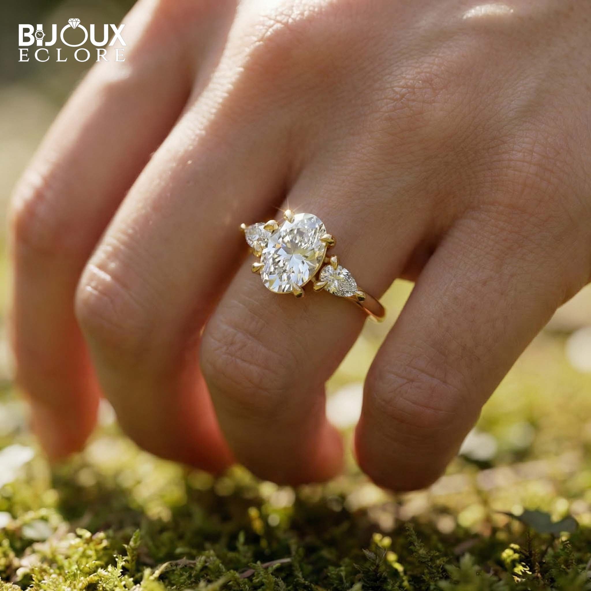 Oval-Cut Center Diamond with Sparkling Trilliant Side Stones Set in a Luxurious Yellow Gold Band - Bijoux Eclore