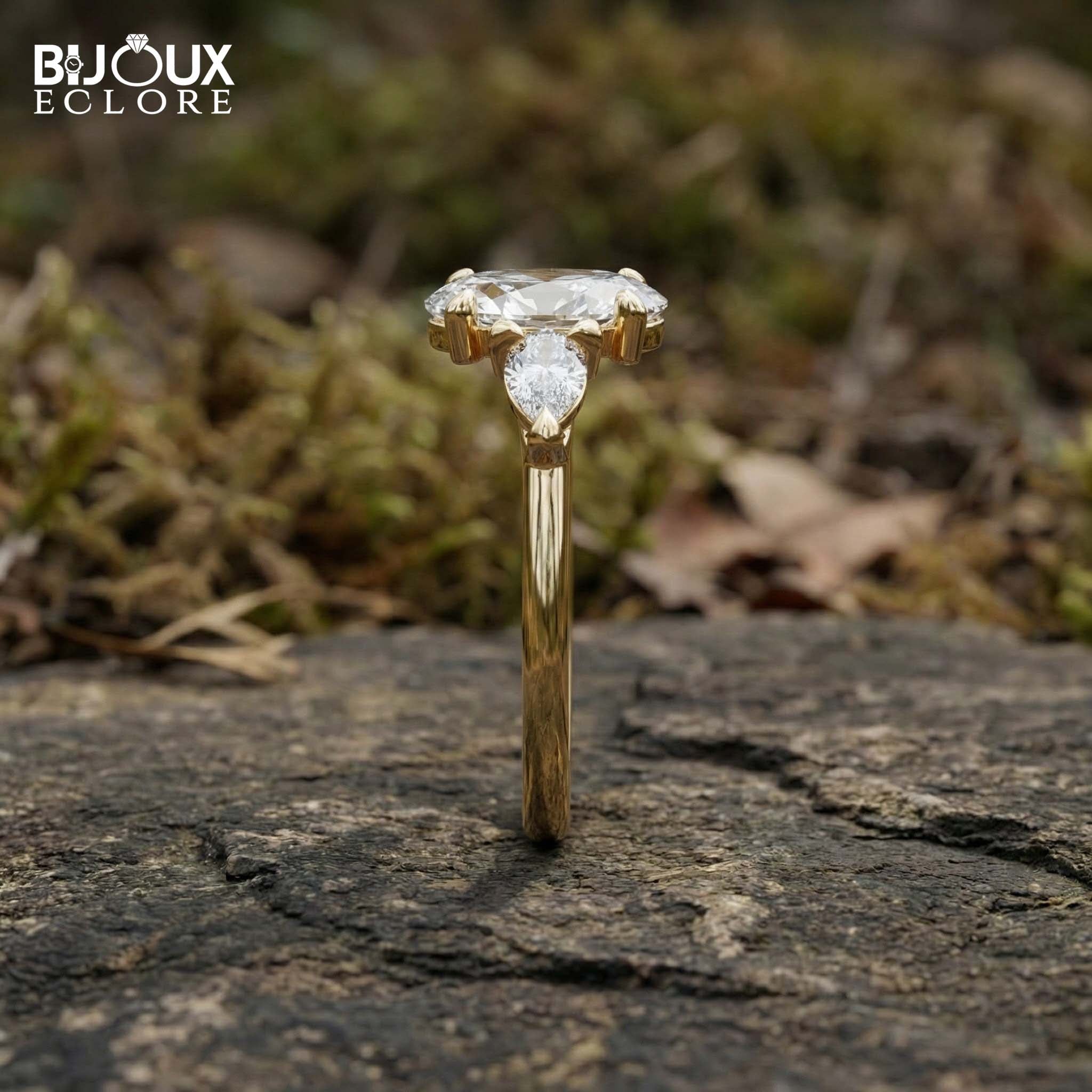 Oval-Cut Center Diamond with Sparkling Trilliant Side Stones Set in a Luxurious Yellow Gold Band - Bijoux Eclore