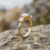 Oval-Cut Center Diamond with Flanking Round Accent Stones Set in a Timeless Yellow Gold Band - Bijoux Eclore