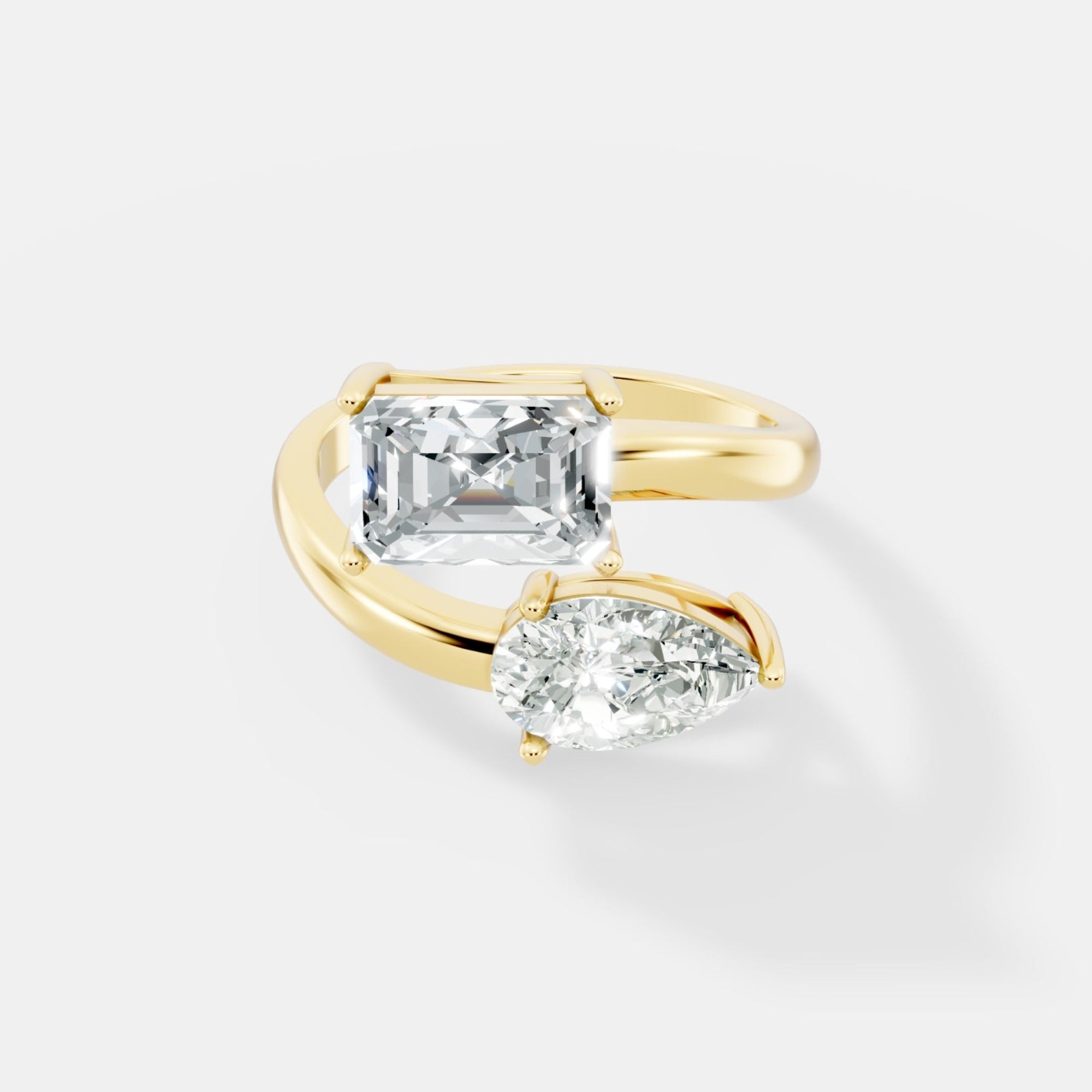 Stunning Dual-Diamond Ring Featuring Emerald and Pear Cut Stones in a Graceful Bypass Design - Bijoux Eclore