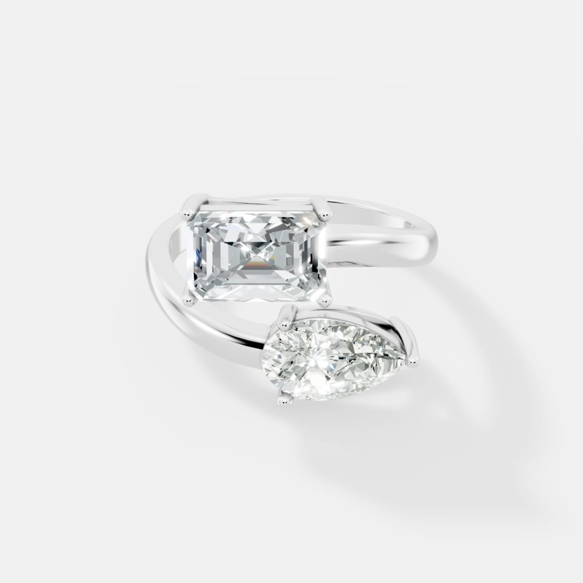 Stunning Dual-Diamond Ring Featuring Emerald and Pear Cut Stones in a Graceful Bypass Design - Bijoux Eclore